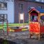 Uteområde med Sandkasse og lekehus laget av tre.