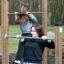 To kvinner trener på Hevestenger/Pull Ups ute i en park.