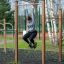 Person som henger i Hevestenger/Pull Ups på lekeplass utendørs.