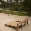 Utendørs treningsplattform Situps med håndtak for magetrening i parkområde.