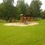 Lonnly lekeplass med huske, sklie og klatrestativ i en park.