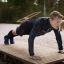 Mann utfører push-ups på Platform F180 i utendørs treningsområde.