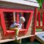 Barn leker i Anna's Playhouse lekehus på lekeplass.