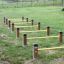 Gul Agility Mini Jump Bars satt opp på en gressplen.
