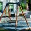 Fugleredehuske Bird Nest Swing (BNS 120 cm) på lekeplass foran bygning.