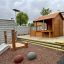 Trelehus Wooden Garden Playhouse w/ Fencing i sklir på lekeplassen.