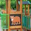 Forest Treehouse lekeplass i tre med bjørnemotiv og grønt rekkverk.