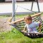 Liten gutt sittende i en Double Hammock (Metal) i hagen.