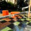 HPL-benk Sjakk og Ludo med sjakkbrettmønster og oransje sitteplasser på lekeplass.