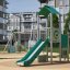 Utkikkspunkt med rutsjebane på moderne lekeplass med grønt underlag.