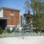 Lekeplassutstyr Pyramidenett foran moderne bygning og grønne planter.