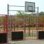 Basketballbane med røde gjerder og en basketballkurv, Aråsen.