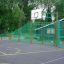 Alfheim lekeplass med basketballbane og grønt gjerde.