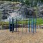 Klatrearena på utendørs lekeplass foran fjellvegg.