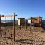 Lekeapparat Lianer Nature på en sandete lekeplass ved sjøen.