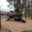 Lekeplass med Ridderborg Nature-klatrestativ i skogsområde.