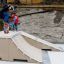 Barn som skateboarder på en Bank H 70 ramp i et utendørs område.