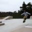 Skater som utfører triks på Bank H 70 i en skatepark.