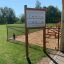 Infoskilt ved lekeplass i en park.