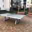 Frittstående Bordtennisbord i betong plassert på brostein i en boligområde.