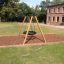 Lekeplass huske Swing Frame (single, wide) på en gresskledd område foran en skolebygning.