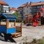 Rød sklie på lekeplass med tårn og klatrevegg.