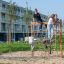 Barn som leker på Klatrenett på lekeplass foran boligblokk.