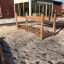 Balansebro på lekeplassen omringet av sand.